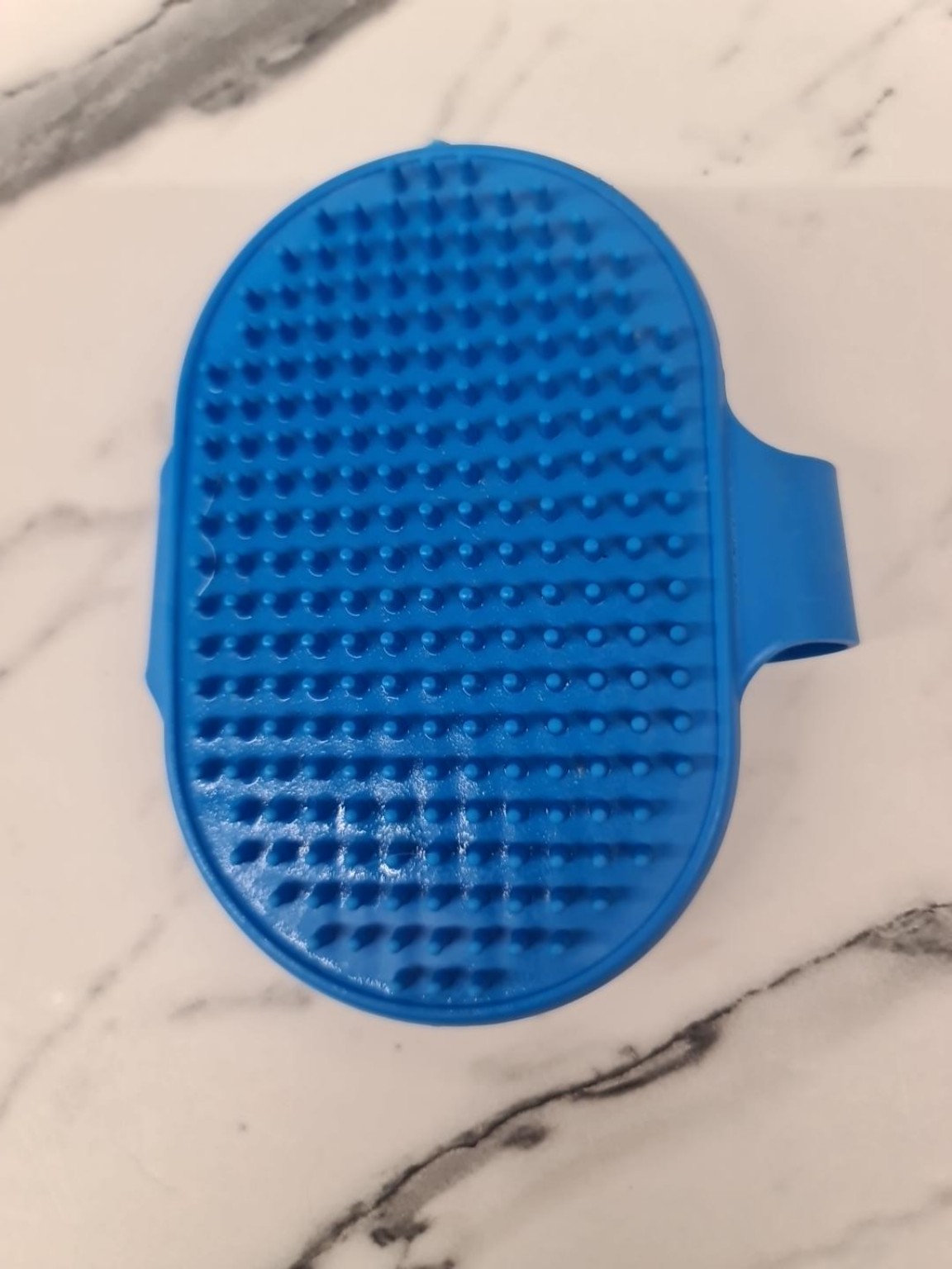 Spazzola da palmo blu originale su una superficie chiara